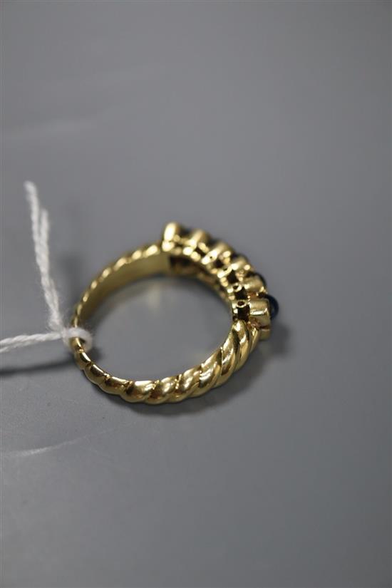 A modern 750 yellow metal, cabochon sapphire and diamond set half hoop dress ring, size R/S, gross 8.7 grams.
